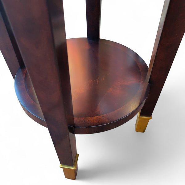 Tradition De France dark wood round accent table with gold accents and lower shelf